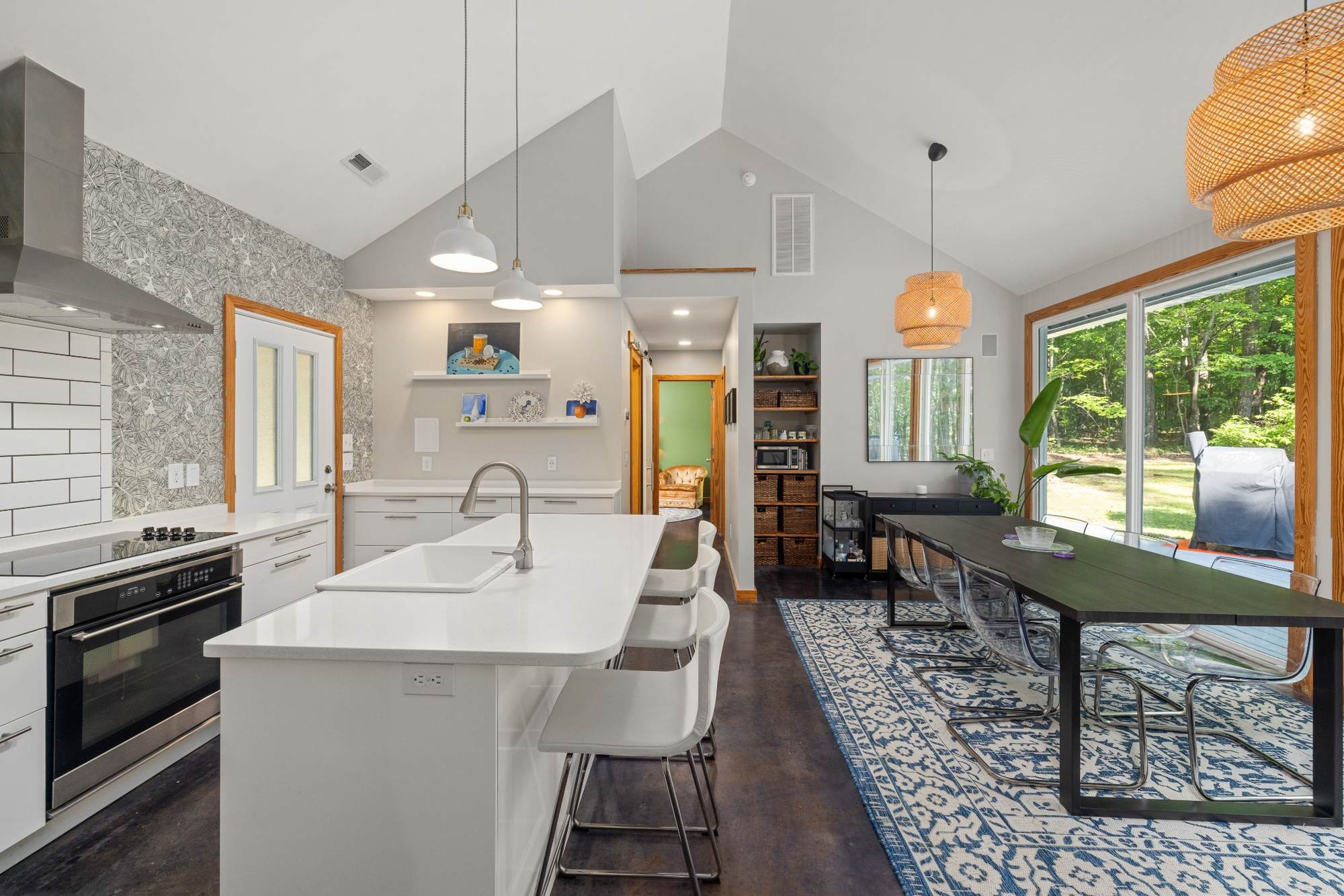 Stock image Vaulted kitchen and dining room with white island and large windows in Northern California - optimized