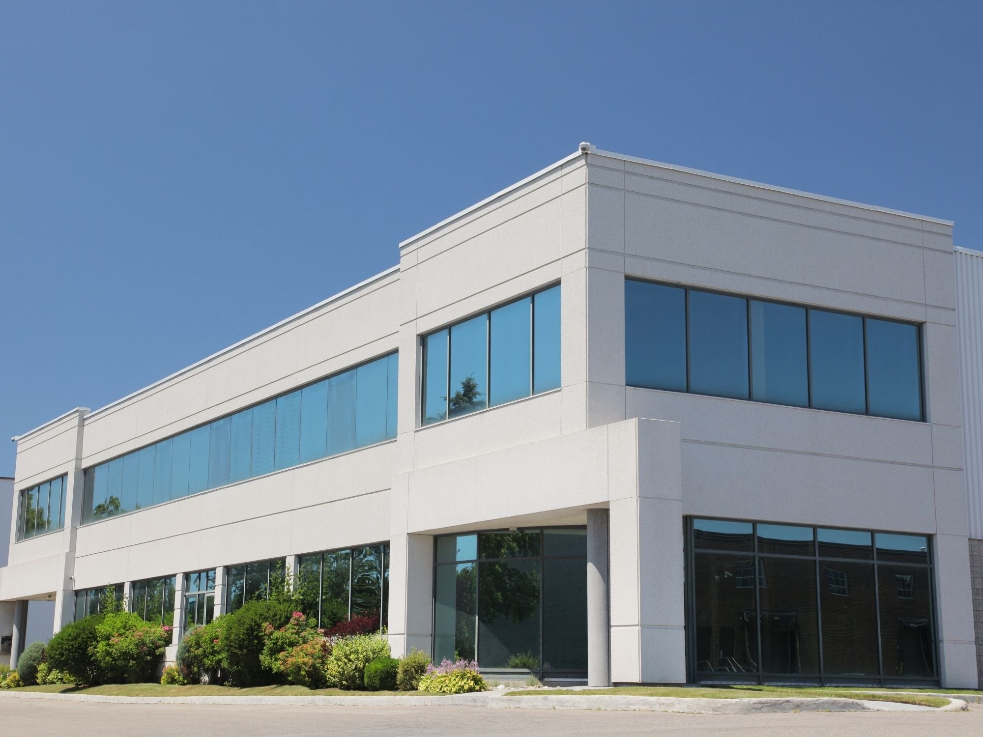 Stock image of a modern commercial office building with white exterior and expansive windows in Northern California - optimized
