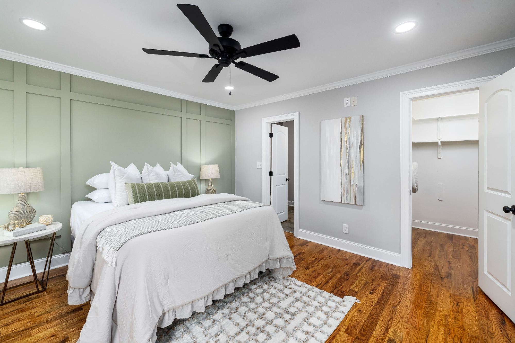 Stock image Bedroom with green accent wall, hardwood floors, and ceiling fan in Northern California - optimized