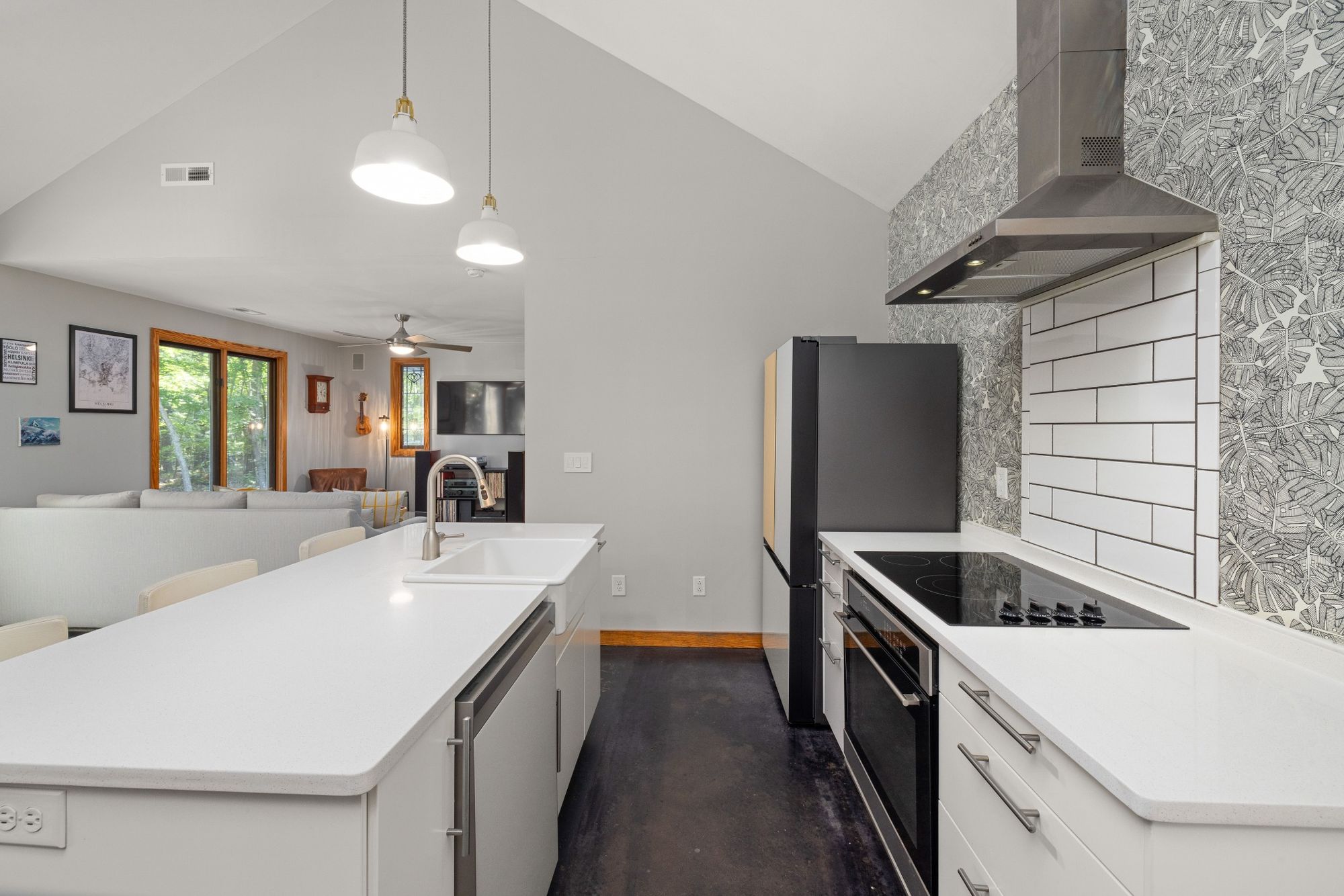 Stock image Modern white kitchen with island, black appliances, and vaulted ceiling in Northern California - optimized