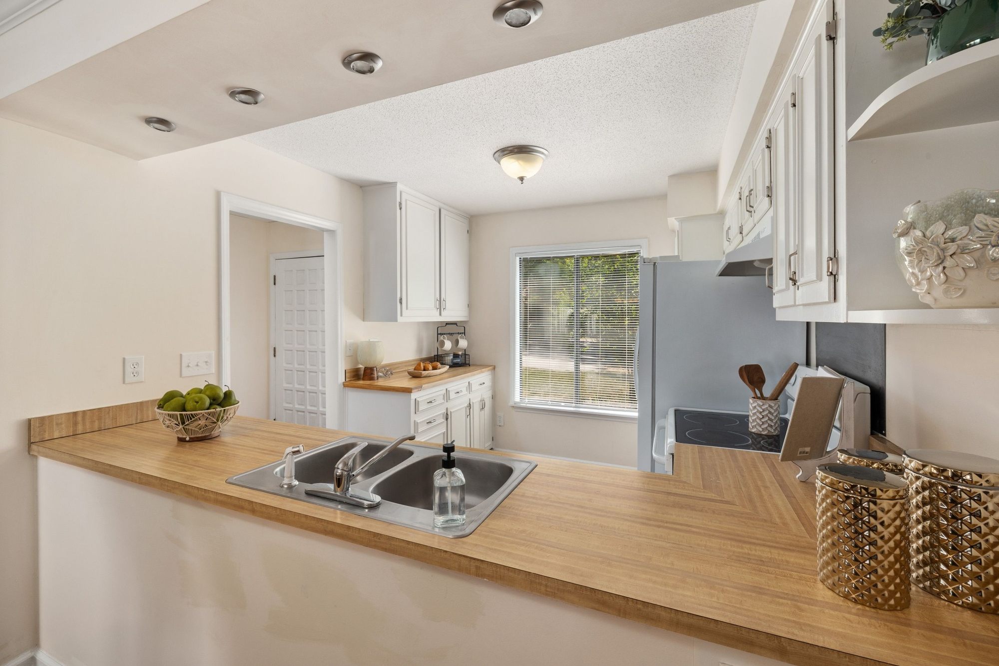 Stock image White kitchen with wood countertops, breakfast bar, and bright cabinetry in Northern California - optimized