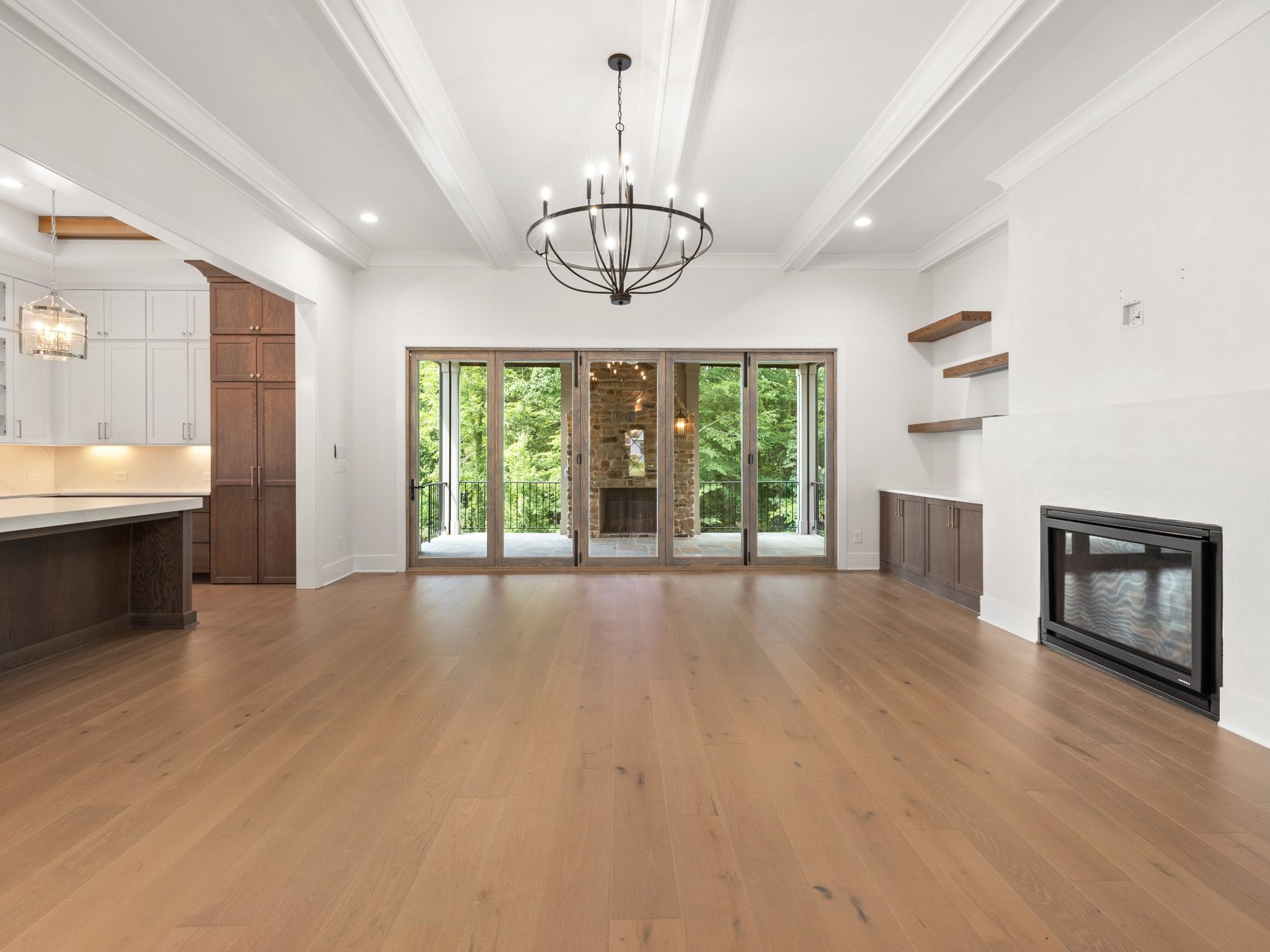 Stock image of an open living space with hardwood floors, fireplace, built-ins, and sliding patio doors in Northern California - optimized