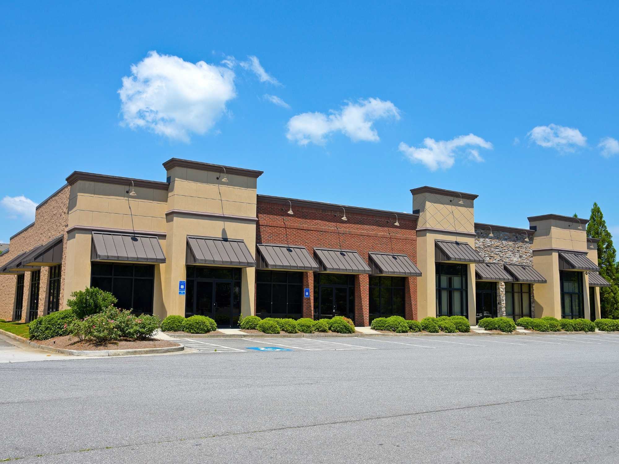 Stock image of a commercial retail building with brick, stone accents, metal awnings, and storefronts in Northern California - optimized