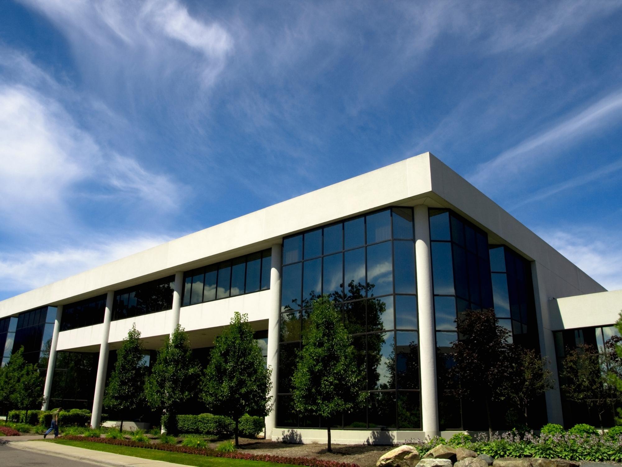 Stock image of a modern commercial office building with large glass windows and landscaping in Northern California - optimized