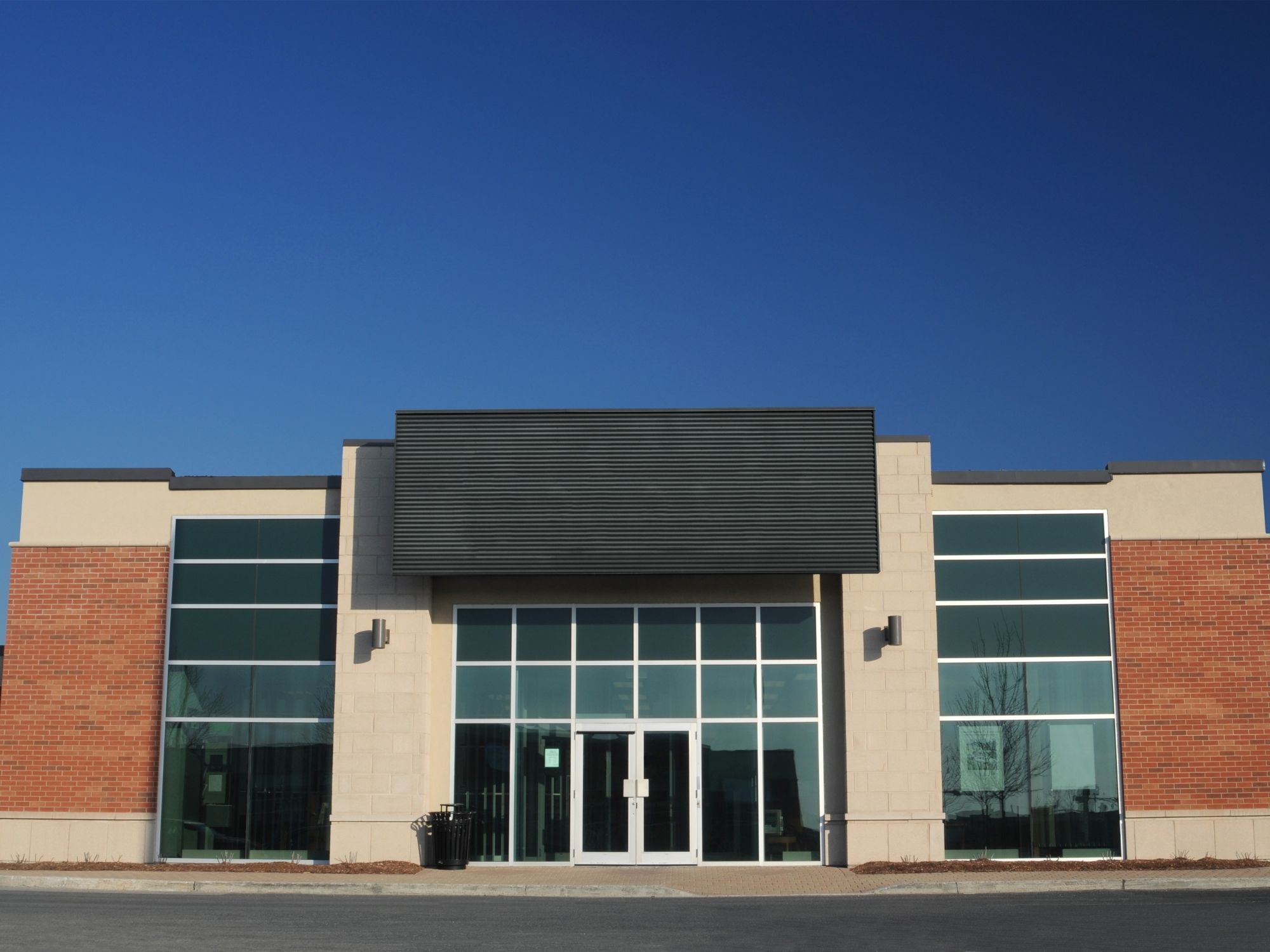 Stock image of a modern commercial storefront with brick accents, large glass windows, and central entrance in Northern California - optimized