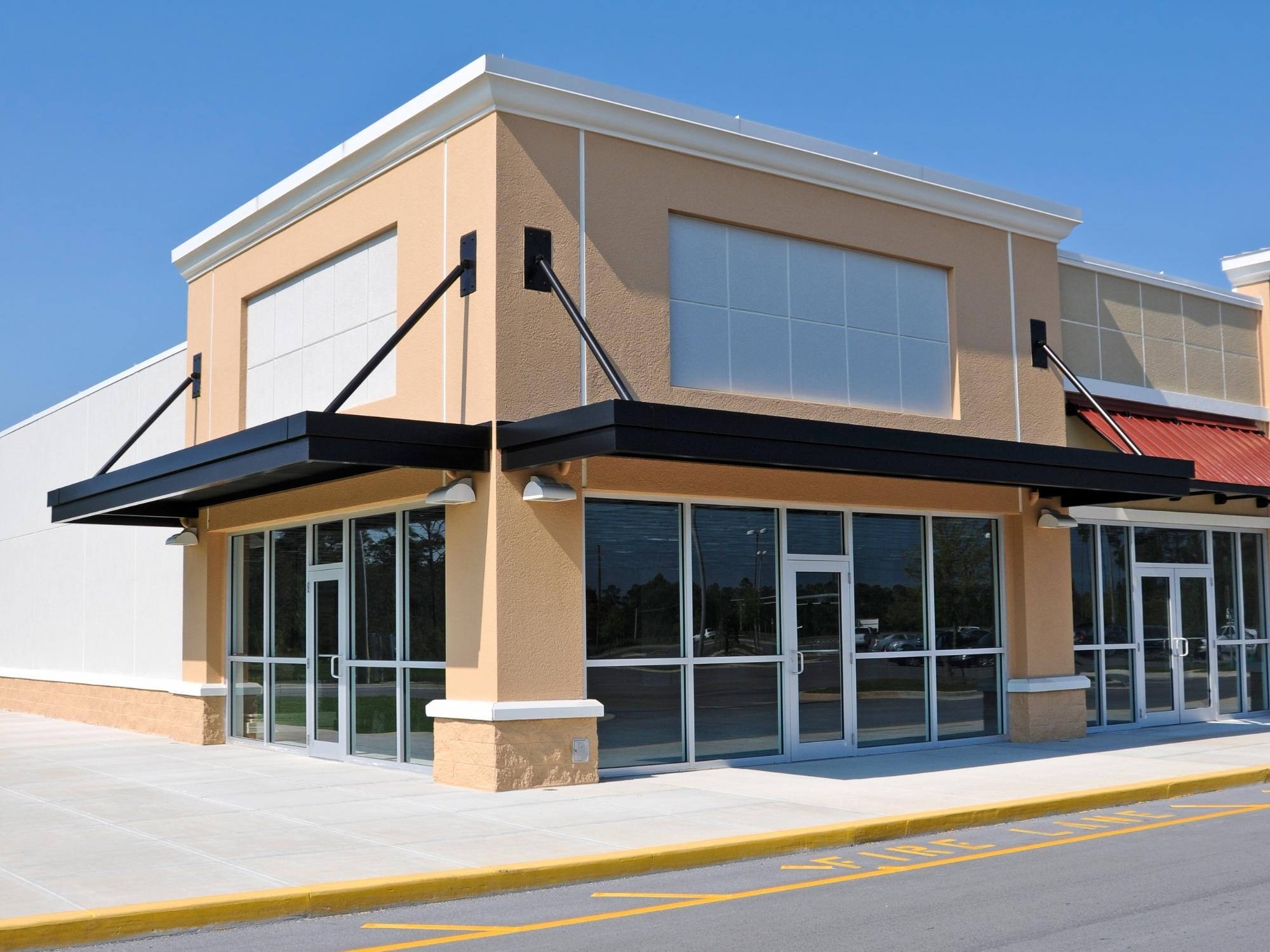 Stock image of a modern commercial storefront with glass entry doors and black awnings in Northern California - optimized