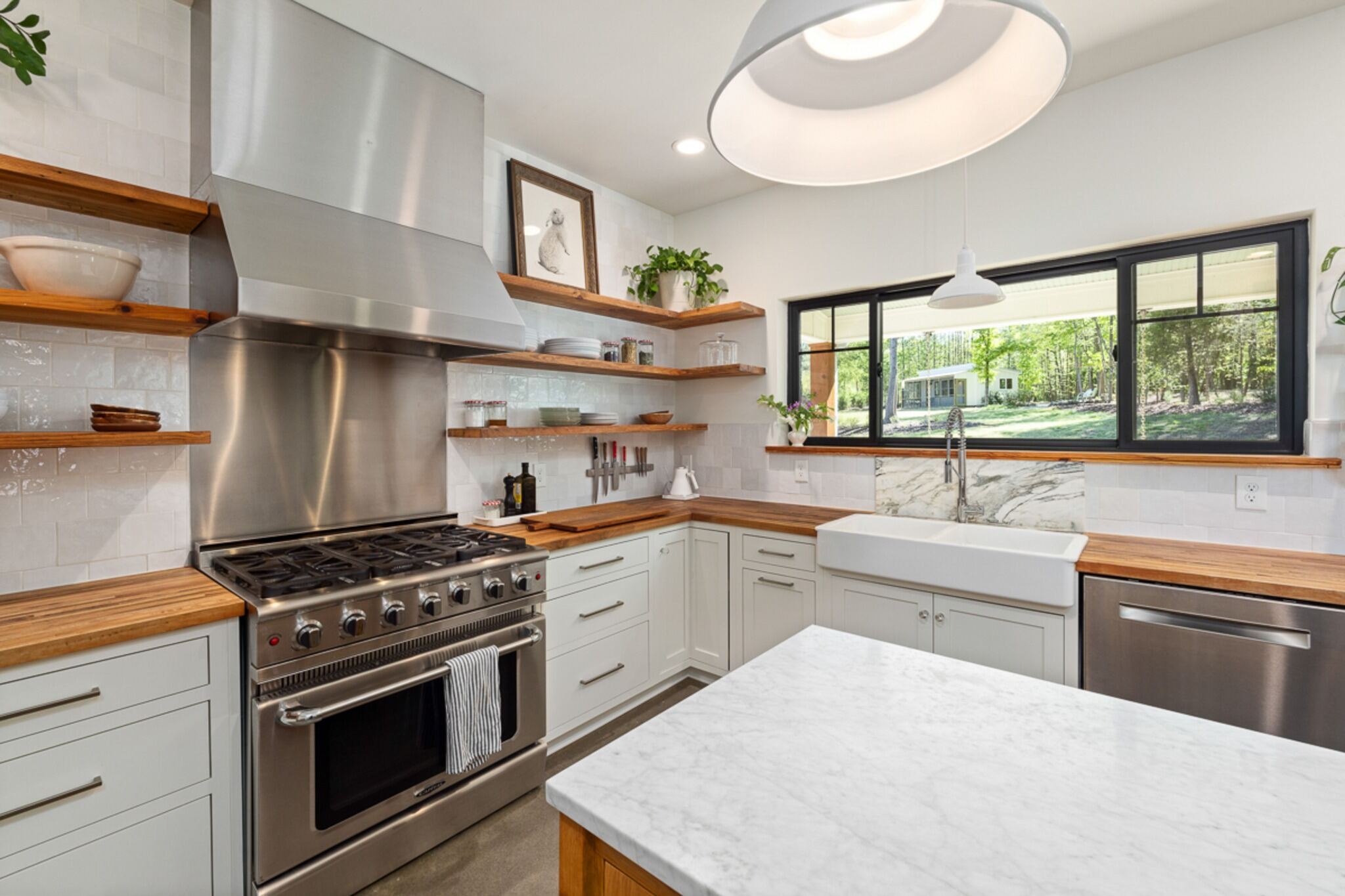Stock image of white kitchen with wood counters, farmhouse sink, open shelving, and large window northern california -optimized