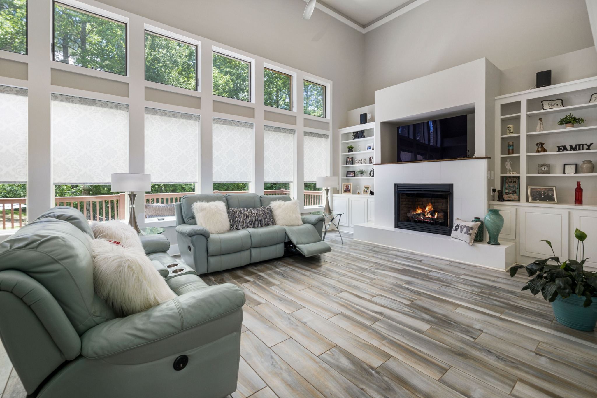 Stock image of a bright living room with large windows, fireplace, built-in shelves, and seating in Northern California -optimized