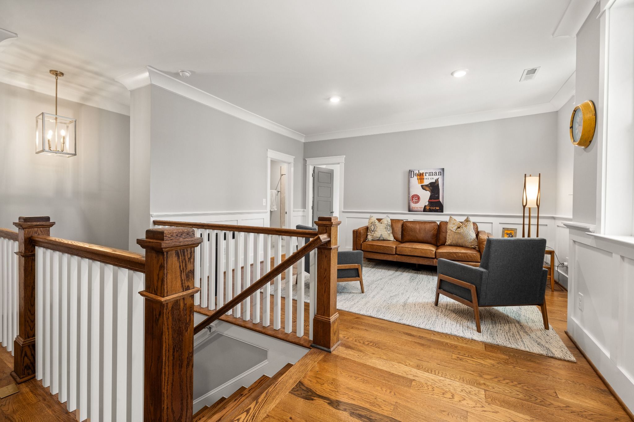 Stock image of an upstairs sitting area with wood floors, staircase, and modern seating in Northern California -optimized